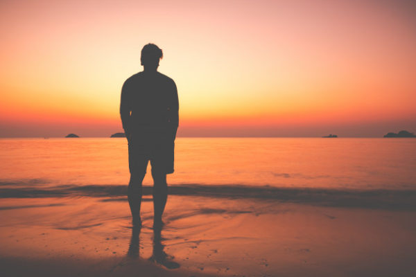 silueta-hombre-sentado-solo-playa_24899-1578